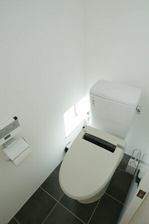 A small, modern bathroom with a toilet, a sink, and a window providing natural light. - Ohenroyado Tabibito no Yado Kaze no Kuguru (Zentsuji)