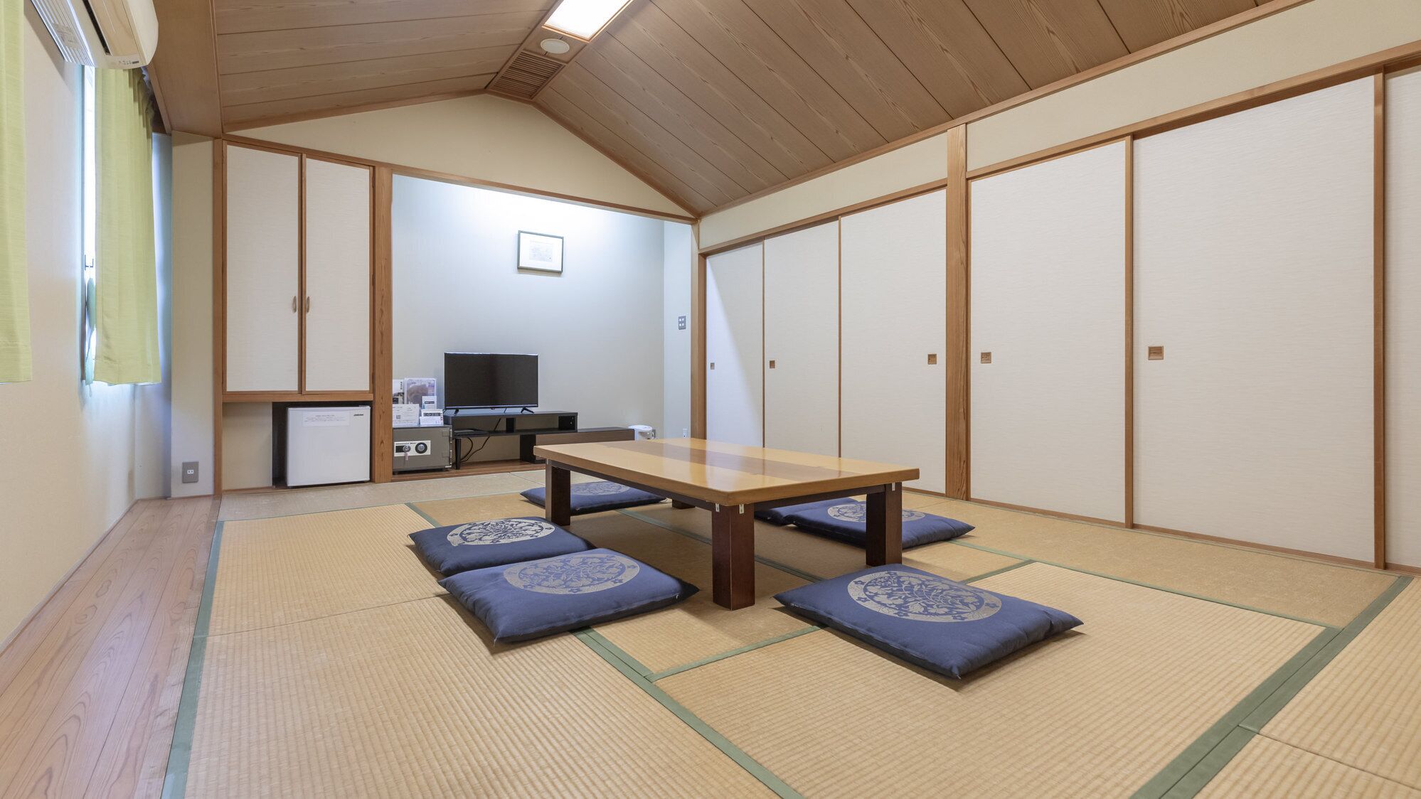 Una habitación tradicional japonesa con suelo de tatami, una mesa de madera baja y puertas correderas shoji.