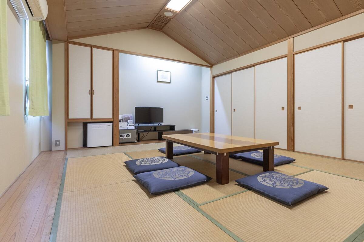 Une pièce de style japonais traditionnel, avec un sol recouvert de tatamis, une petite table en bois et des paravents en papier de riz (shoji).