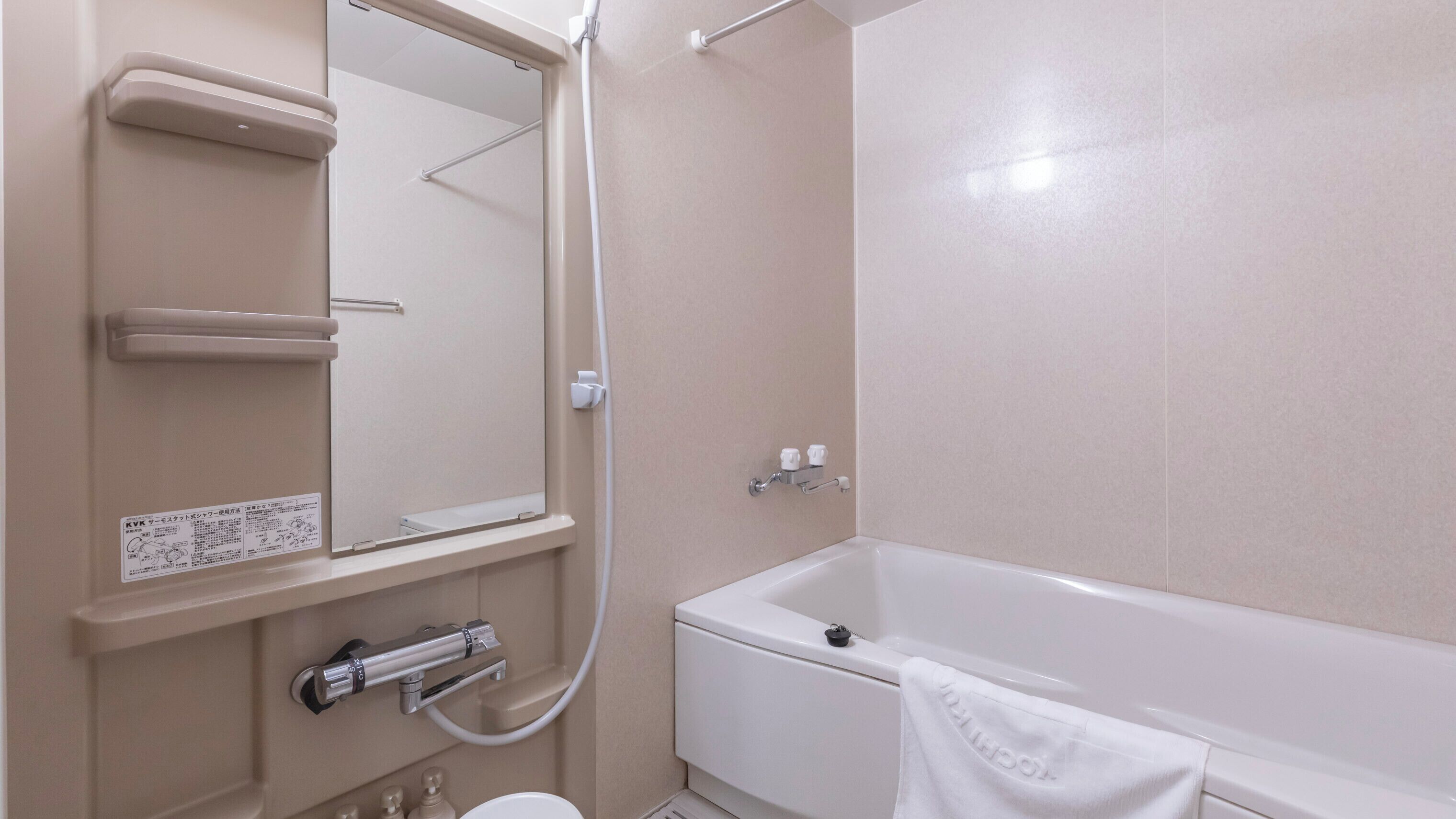 A bathroom with a bathtub, a toilet, a sink, a mirror, and a towel rack.