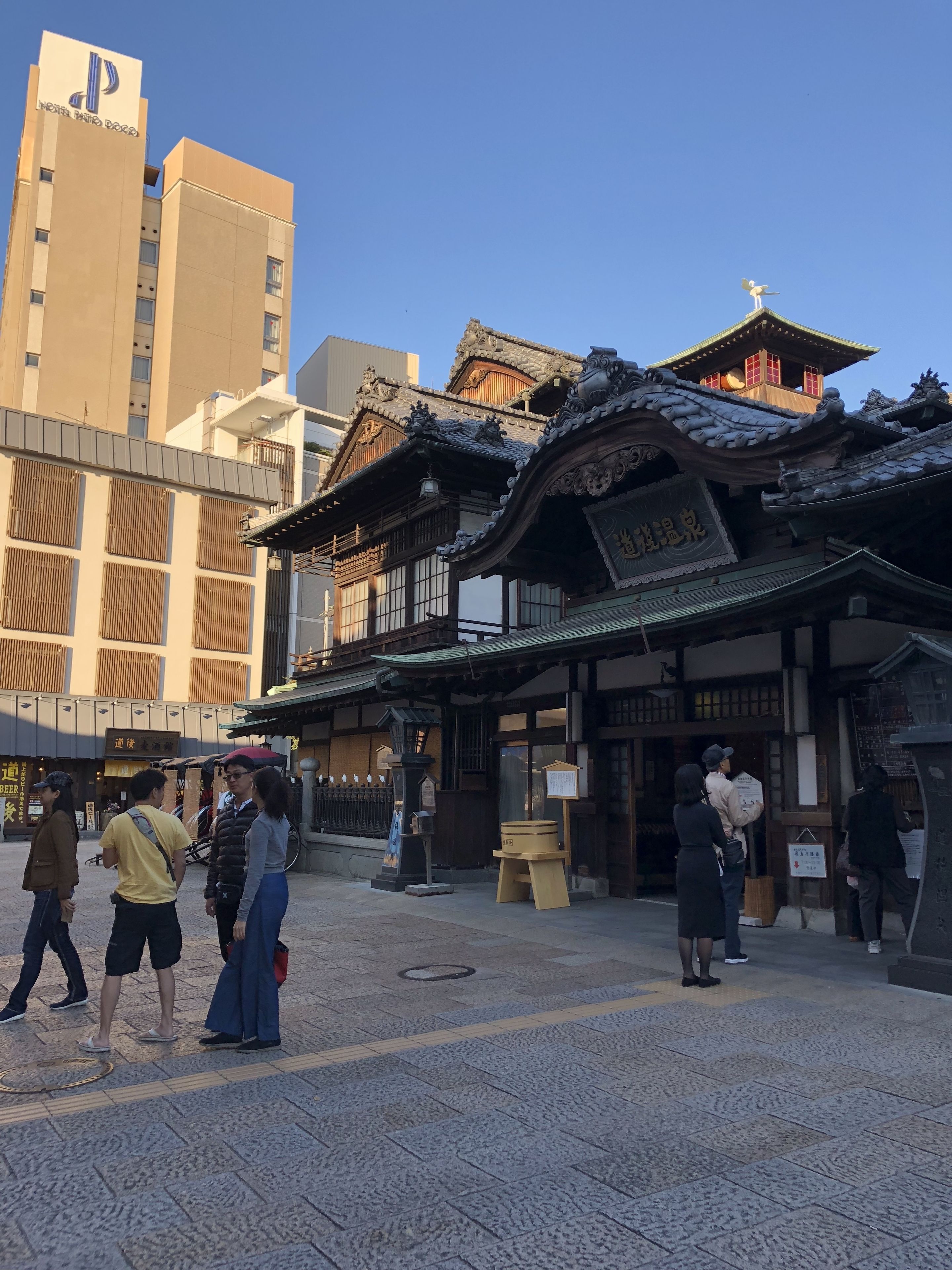 Un edificio japonés tradicional con tejado al estilo pagoda, rodeado de edificios modernos.