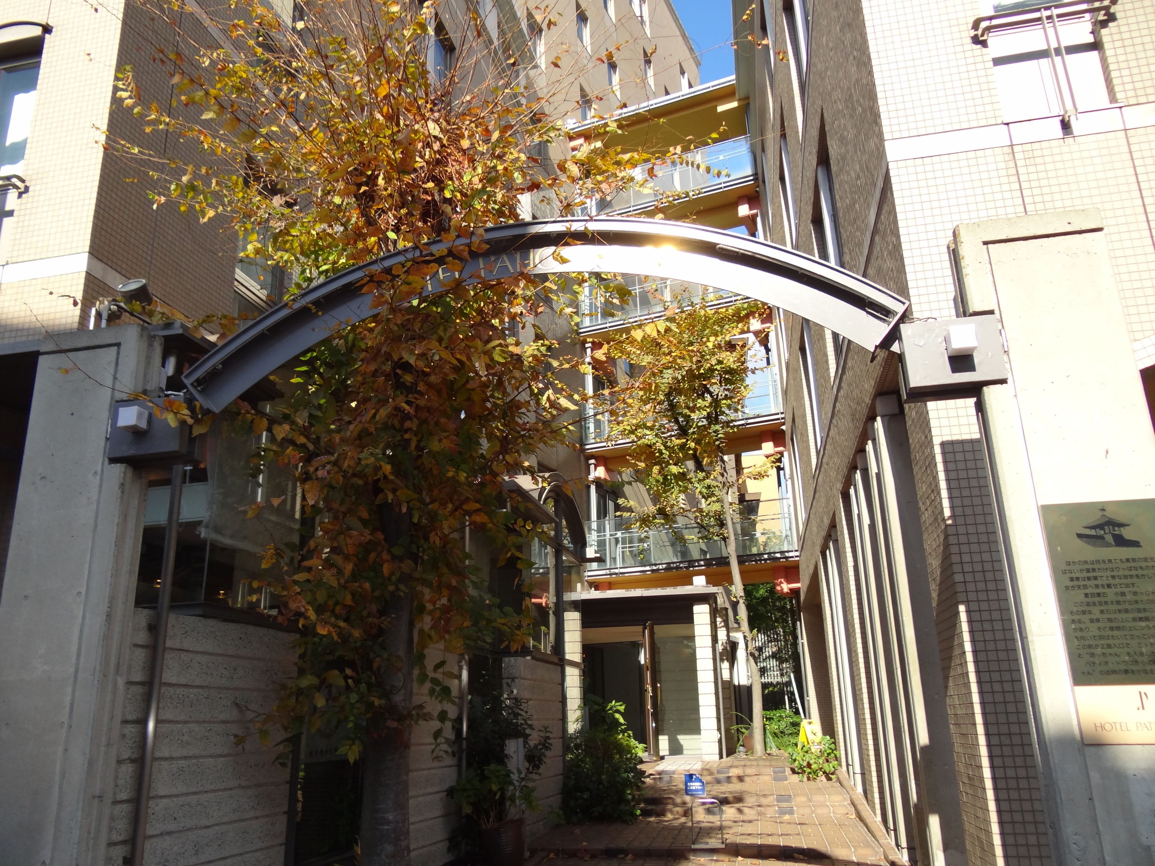A hotel entrance with a curved metal archway, a brick facade, and a signboard.