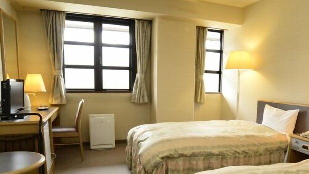 A hotel room with two beds, a desk with a computer, a chair, and a window with curtains. - Tatsuno Park Hotel (Tatsuno)