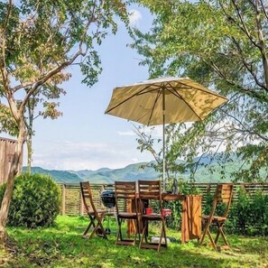 An outdoor seating area with a table, chairs, and a large umbrella.