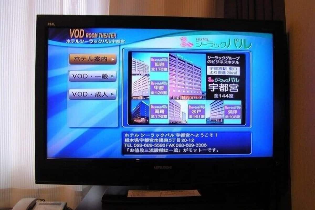 Ein Hotelzimmer mit Beschilderung für ein VOD-Kino, verschiedenen Zimmerausstattungen und Kontaktinformationen.