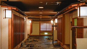 Un interior japonés tradicional con suelo de tatami, puertas correderas y biombos de papel.