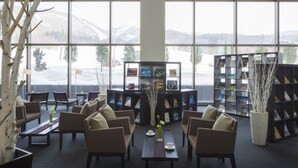 A cozy reading area with sofas, a coffee table, and bookshelves, overlooking a snowy mountain landscape. - Hoshino Resorts Bandaisan Onsen Hotel (Bandai)