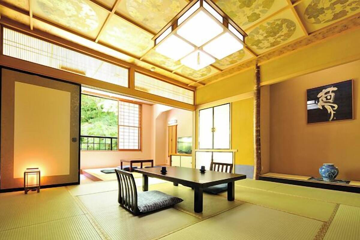 A traditional Japanese room with tatami flooring, a low table, and sliding doors.