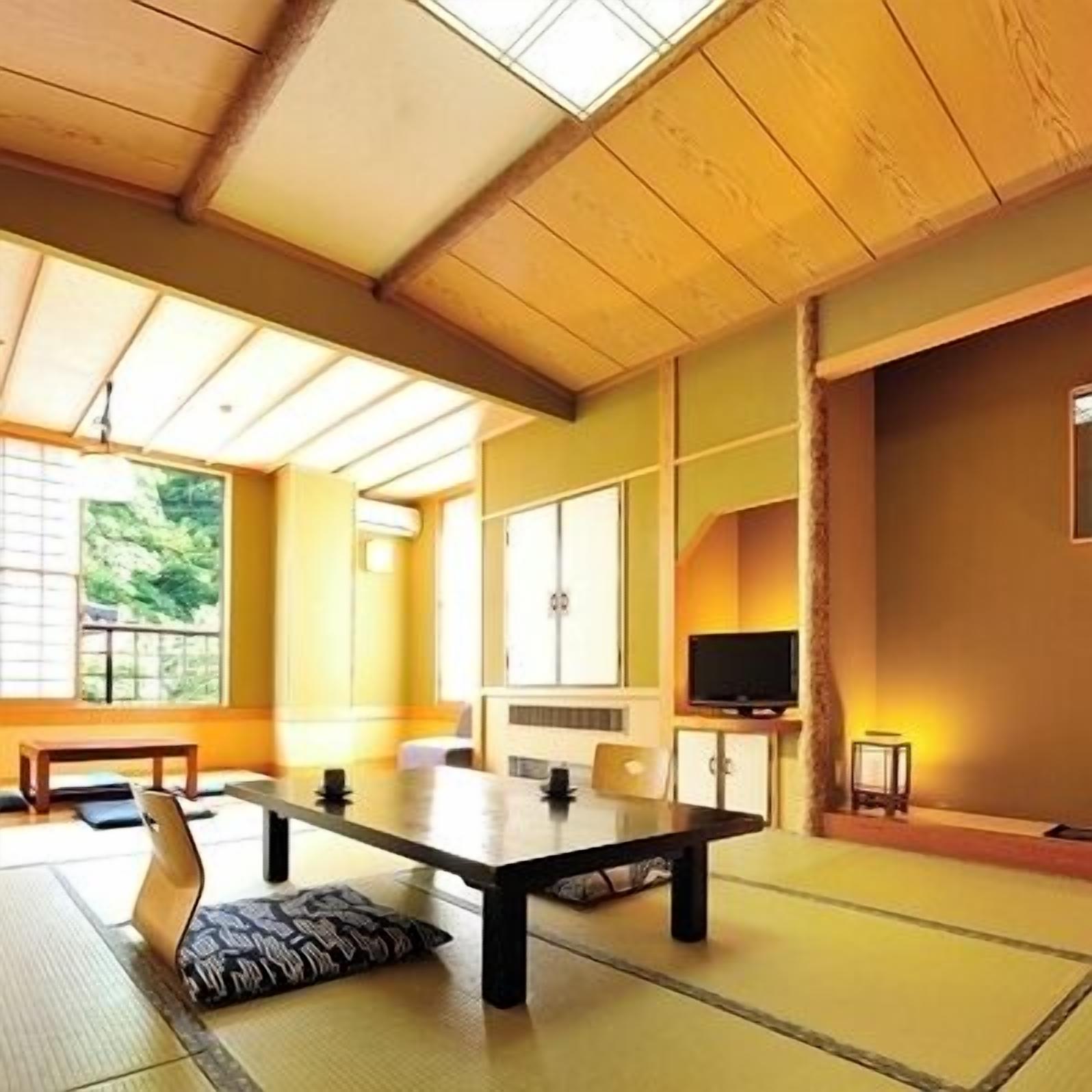 A traditional Japanese-style room with tatami flooring, a low table, and sliding doors.