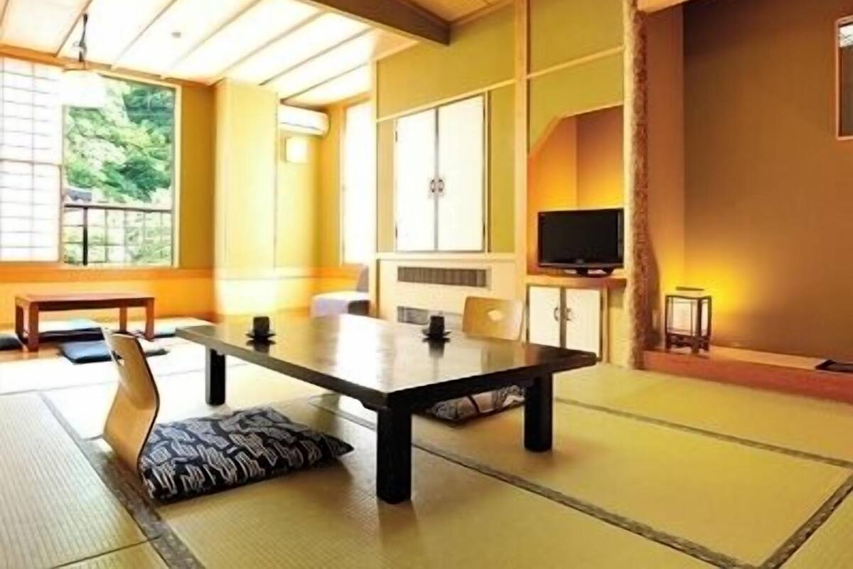 A traditional Japanese-style room with tatami flooring, a low table, and sliding doors.