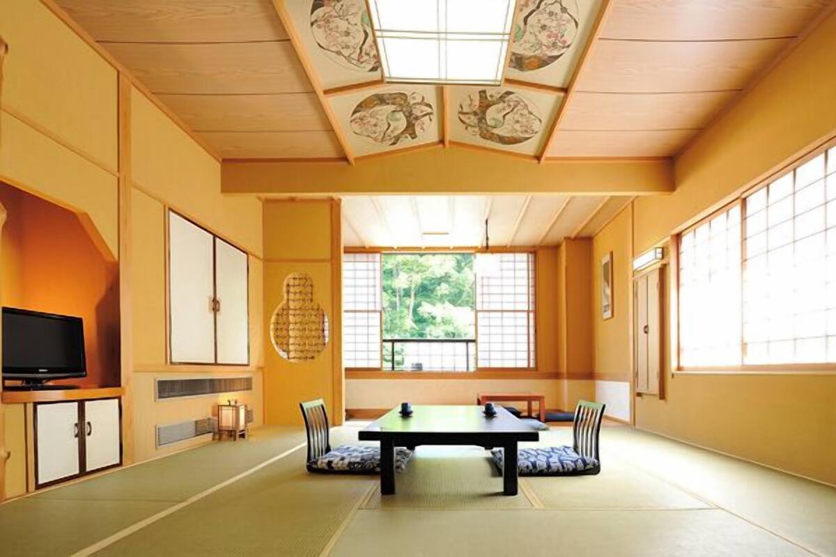 A traditional Japanese room with tatami flooring, a low table, and sliding doors.