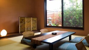 A traditional Japanese room with tatami flooring, a low table, cushions, and sliding doors. - Ashihara Onsen Hakuwaso (Awara)