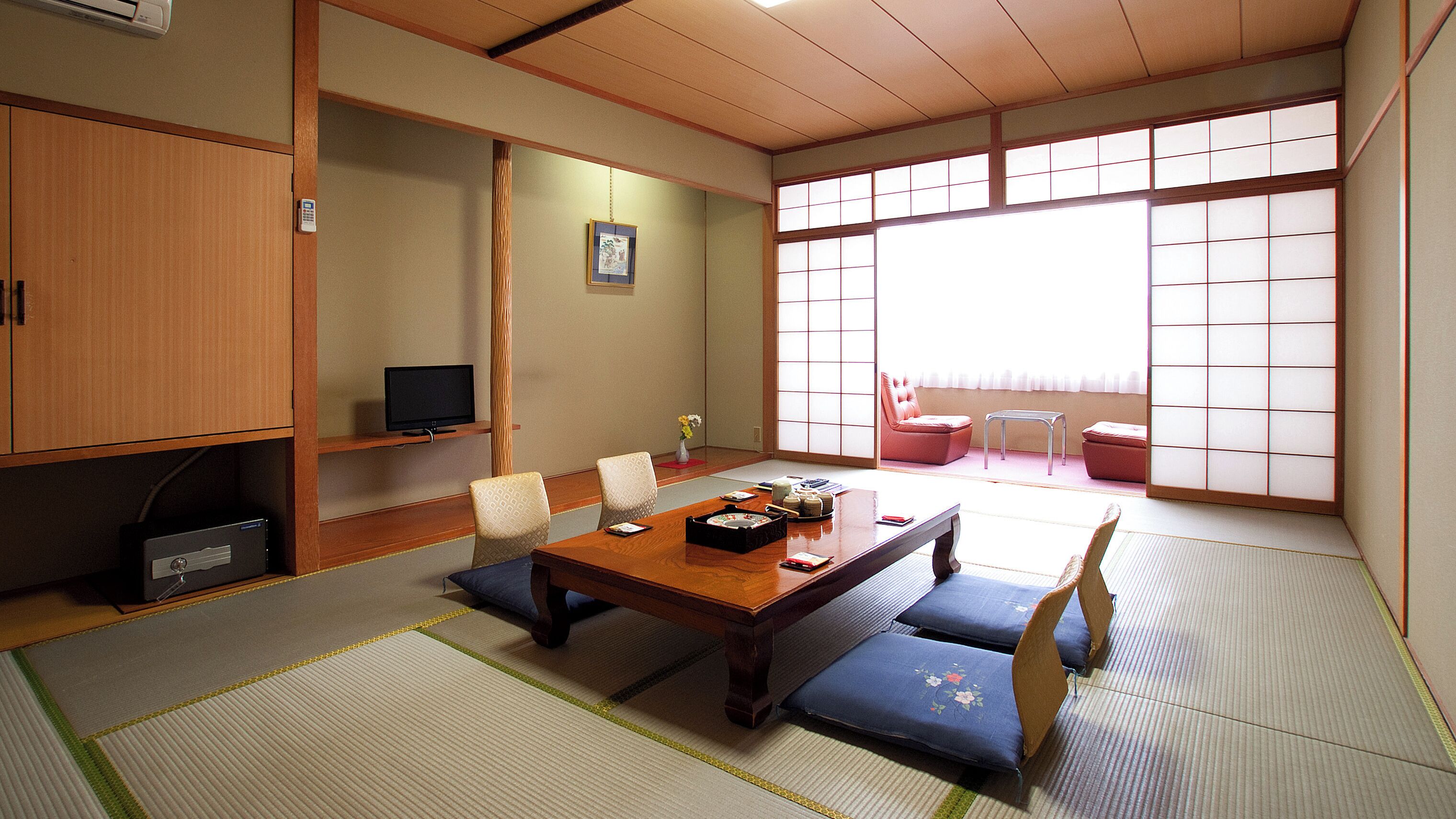 A traditional Japanese room with tatami flooring, a low table, and shoji screens.