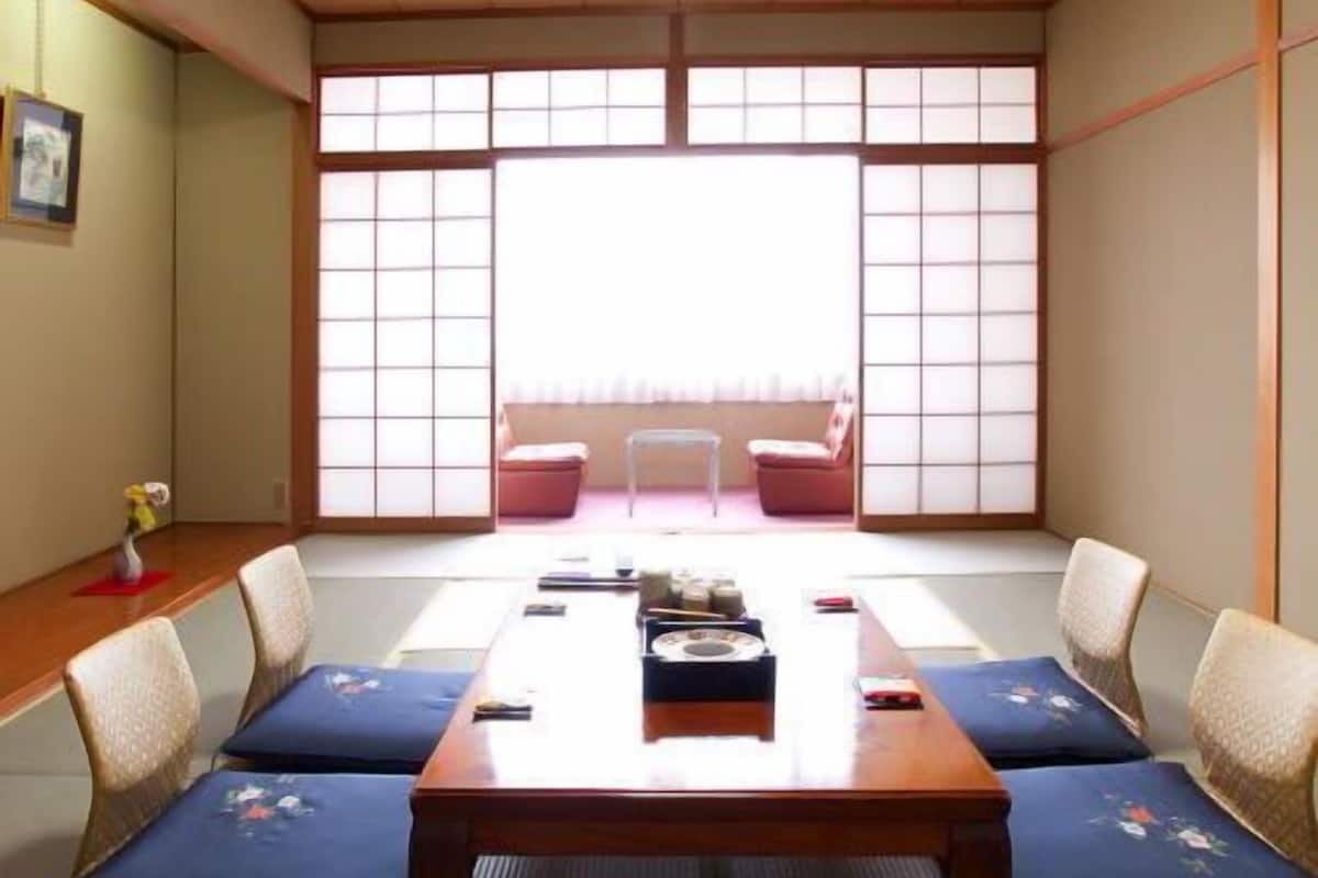 A traditional Japanese room with tatami flooring, a low wooden table, and shoji screens.