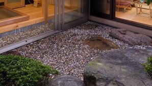 A modern building with a glass exterior, a wooden interior, and a gravel courtyard. - Ashihara Onsen Hakuwaso (Awara)