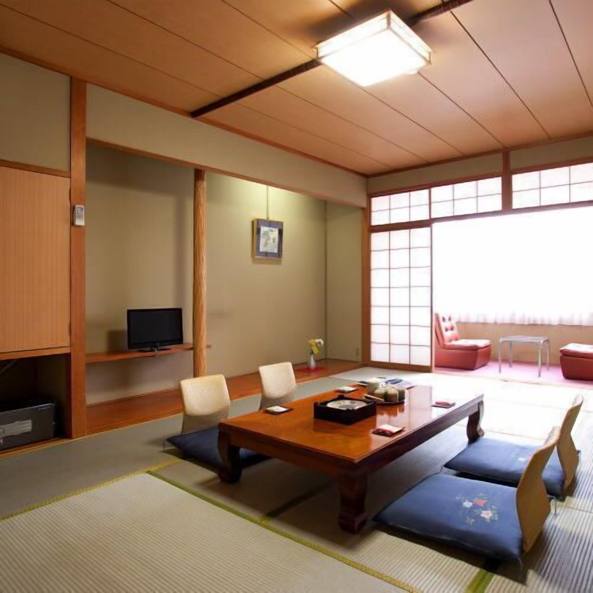 A traditional Japanese room with tatami flooring, a low table, and sliding doors.
