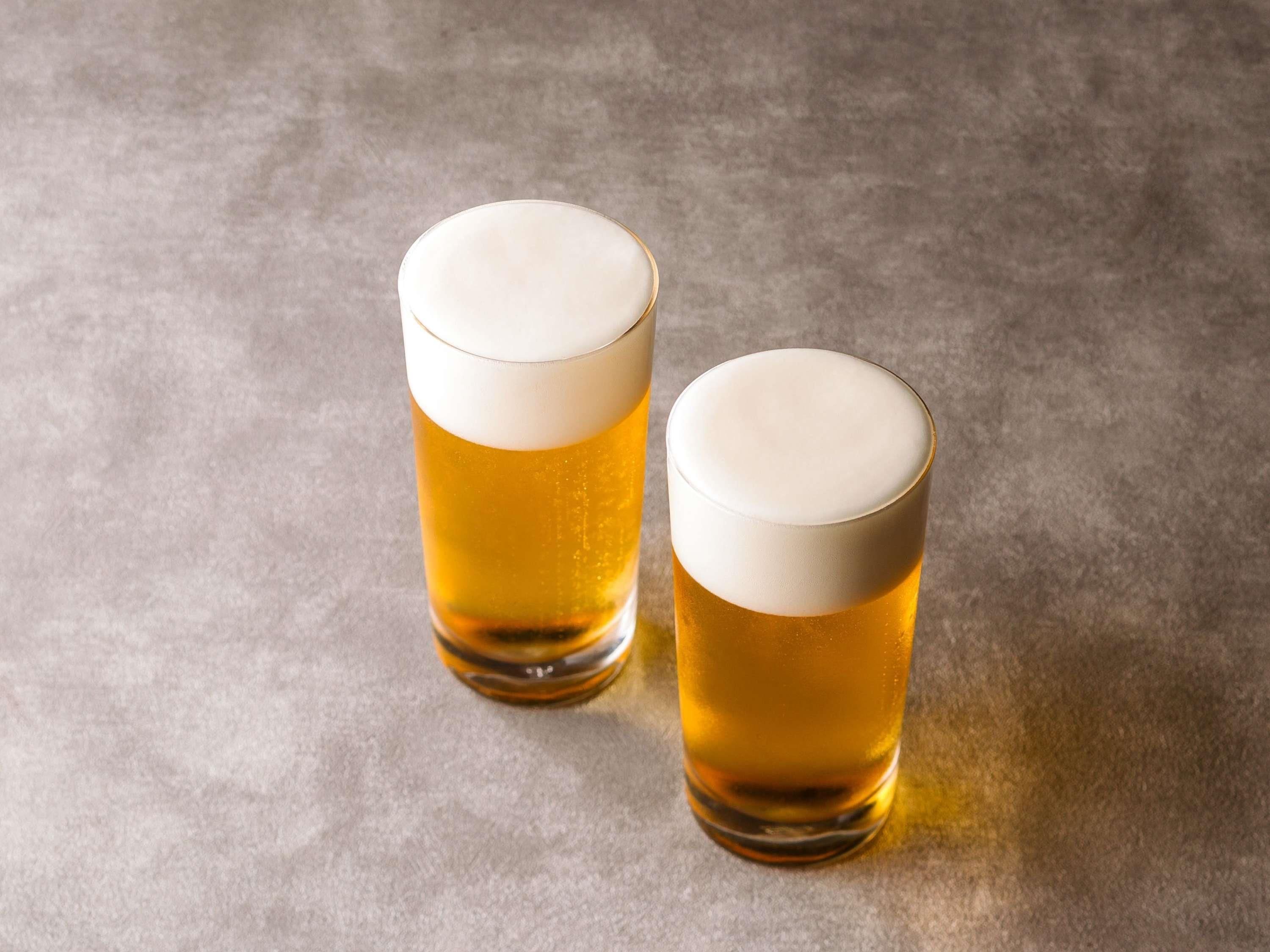 Dos vasos de cerveza sobre una superficie rugosa.