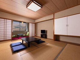 Una habitación japonesa tradicional con suelo de tatami, una mesa baja, una silla verde, un televisor y un armario.