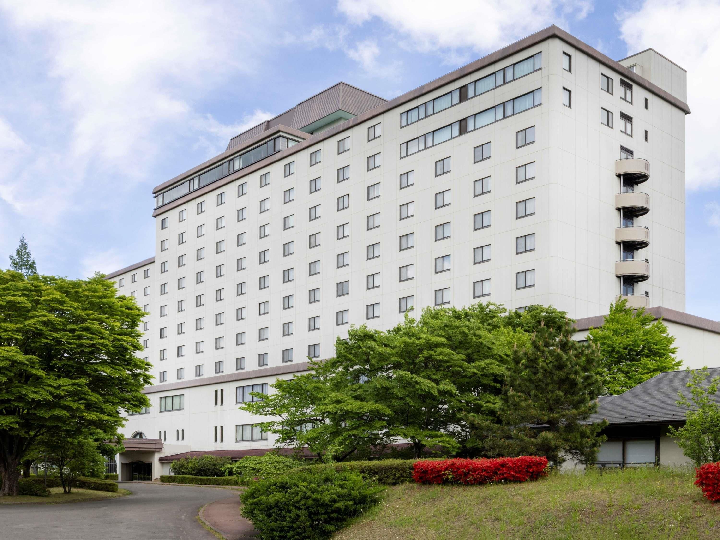 A multi-story hotel with a symmetrical facade, large windows, and a central entrance.
