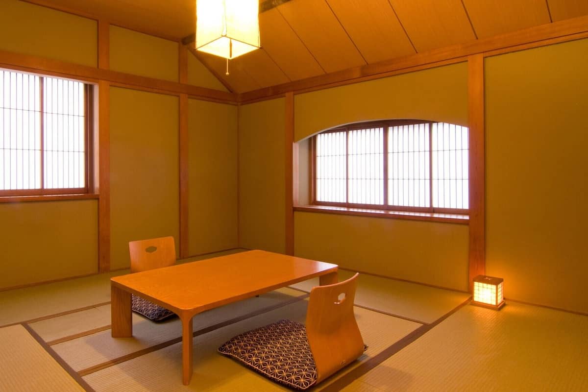 A traditional Japanese room with tatami flooring, a low wooden table, and sliding shoji doors.