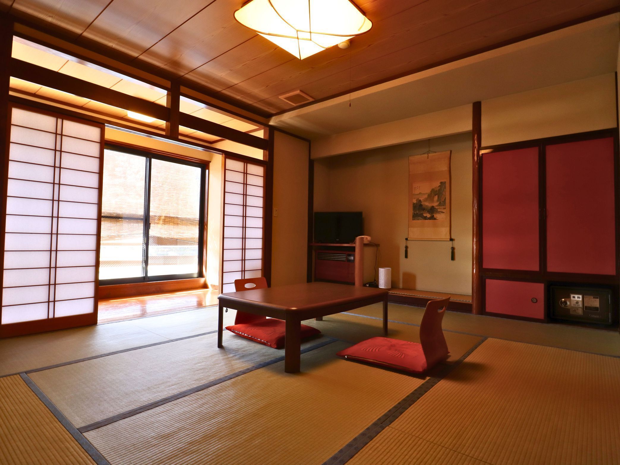 Una habitación japonesa tradicional con suelo de tatami, una mesa baja y puertas correderas.