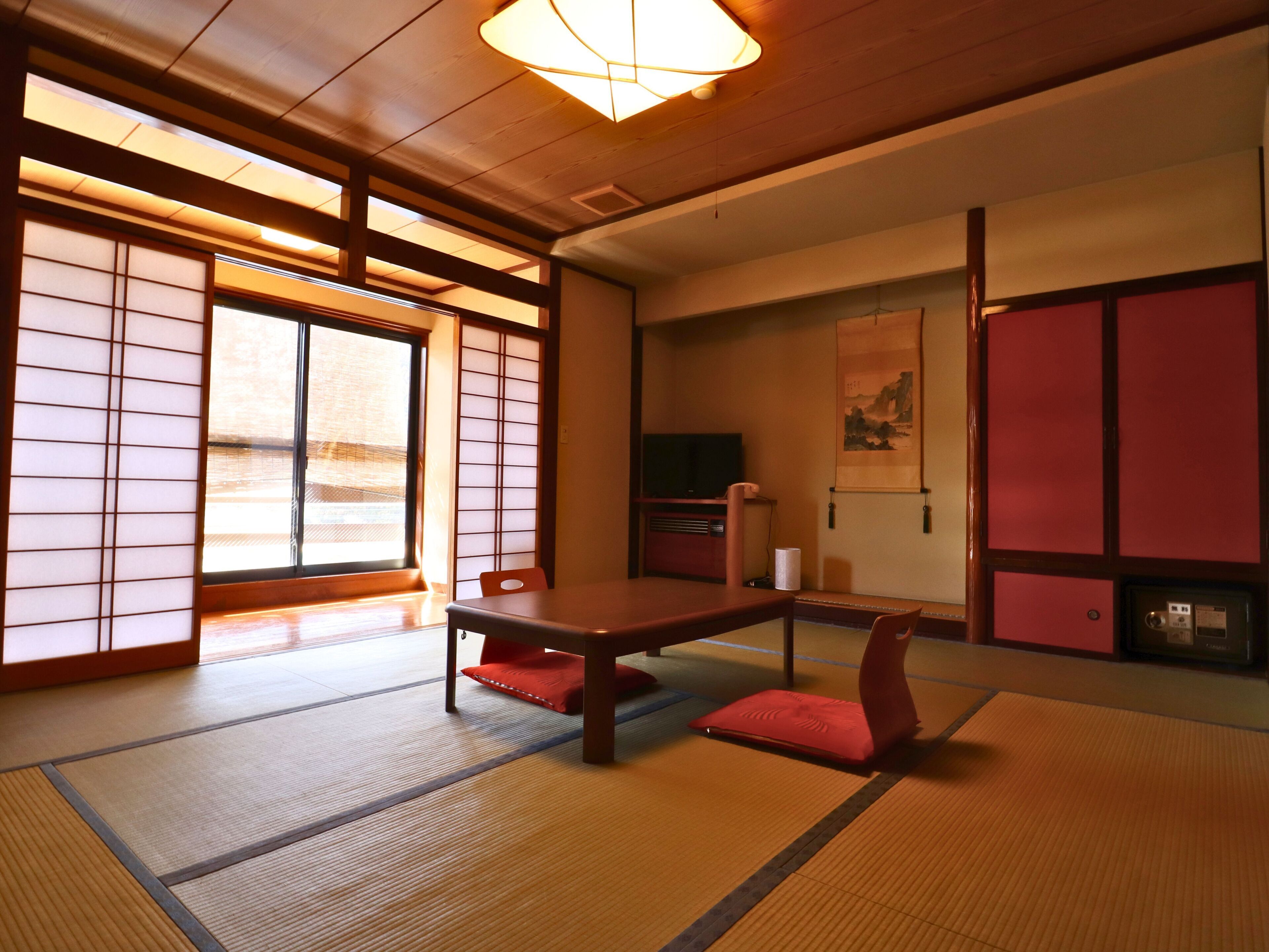 Une pièce de style japonais traditionnel, avec un sol recouvert de tatamis, une table basse et des portes coulissantes.