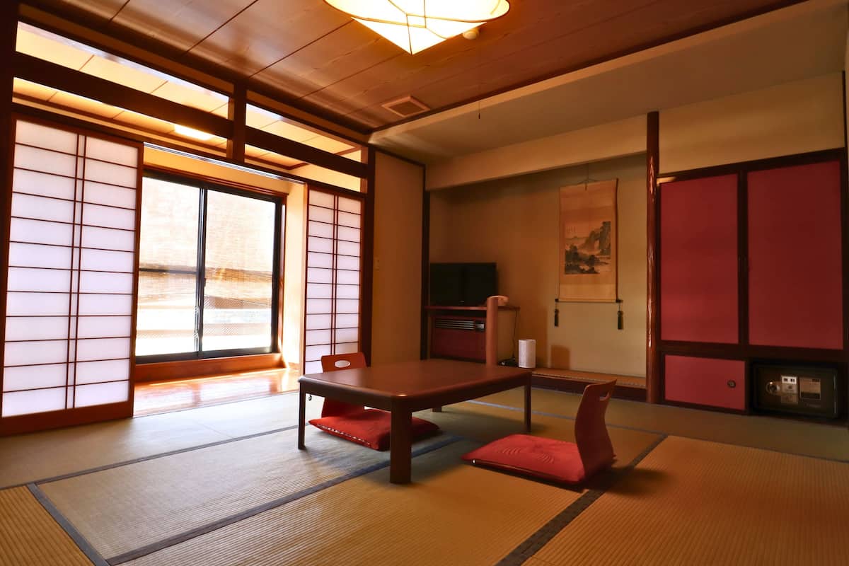 A traditional Japanese room with tatami flooring, a low table, and sliding doors.
