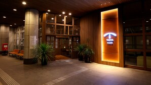 Een hotel lobby met een houten plafond, een receptiebalie en een bord met 'TAOYA'.