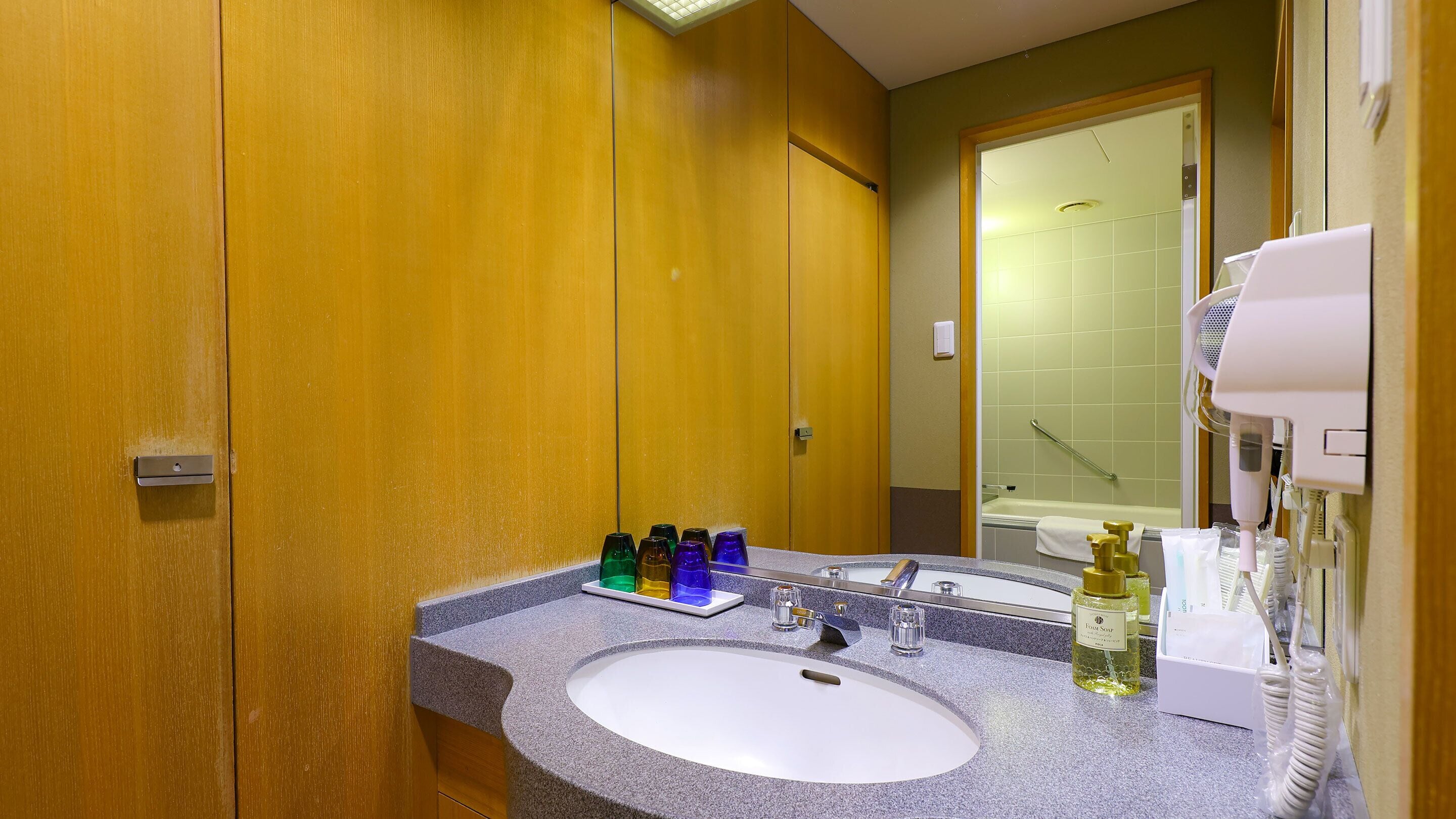 A bathroom with a sink, mirror, and various toiletries.