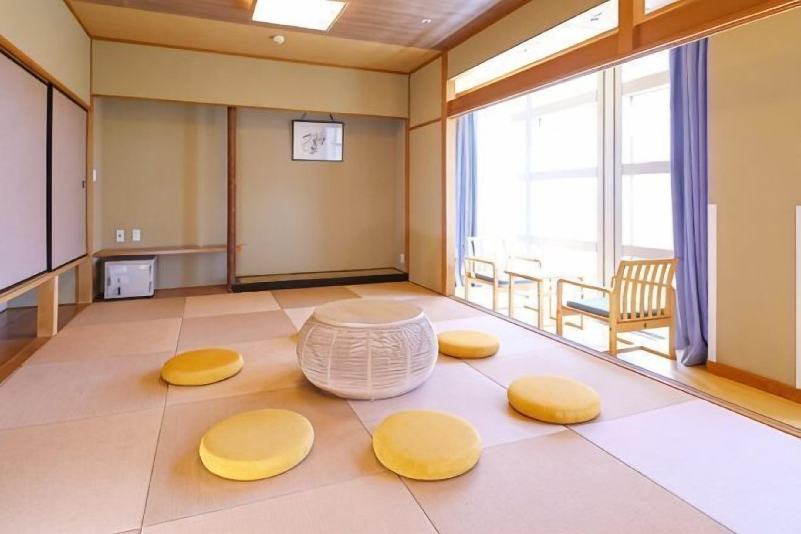 A tatami mat room with tatami mats, a round tatami mat, and a wooden chair.