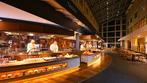 Een buffetgedeelte met diverse food stations en een zithoek met tafels en stoelen.