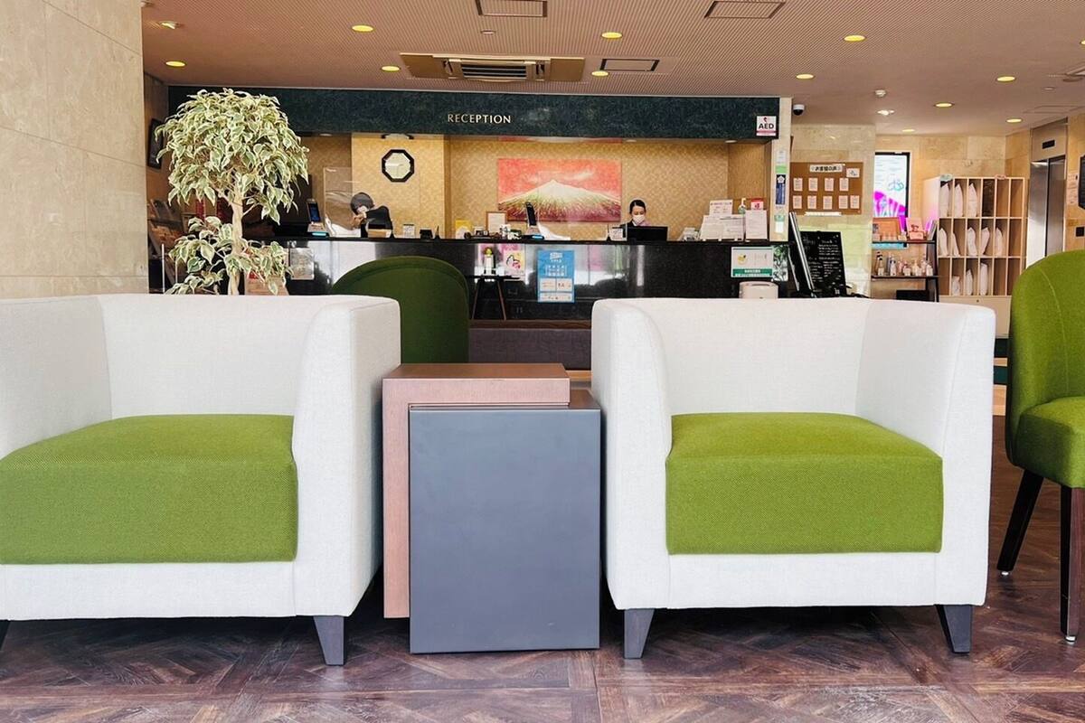 A reception area with a reception desk, a clock, and a plant.