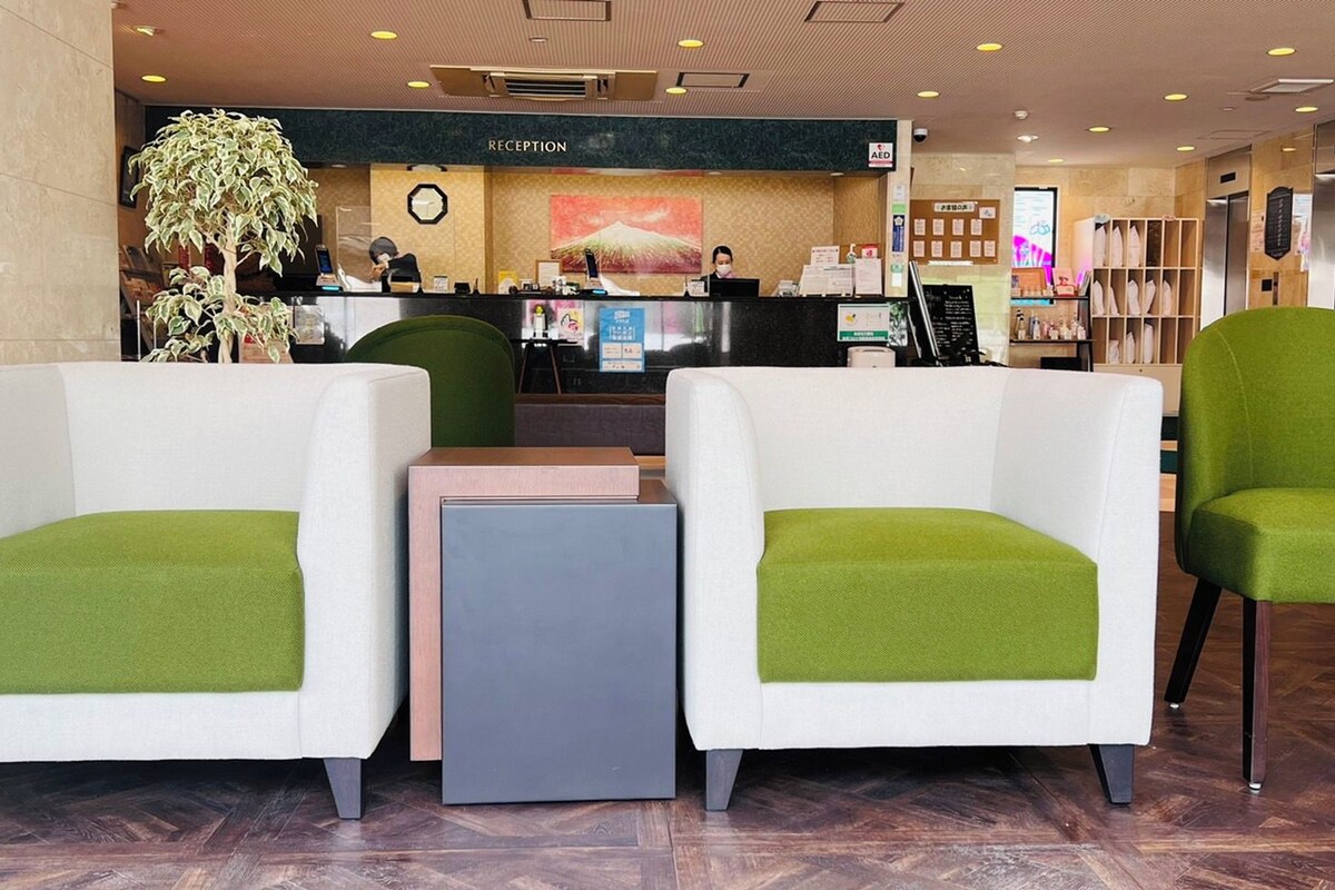 A reception area with a reception desk, a clock, and a plant.
