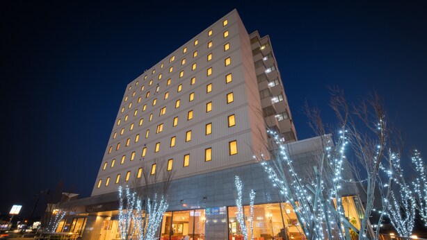 Un hotel moderno a più piani, con ampie vetrate e un ingresso ben visibile.