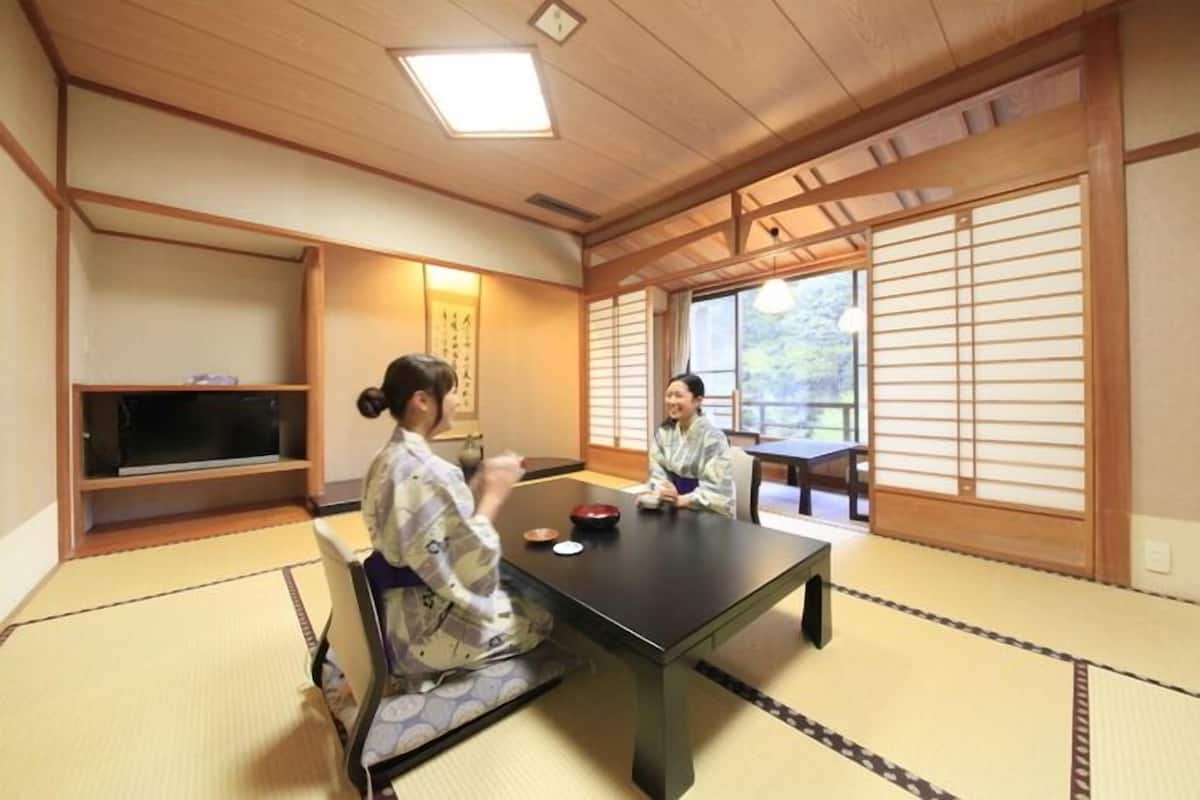 A traditional Japanese room with tatami flooring, a low table, and sliding doors.