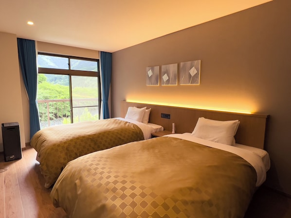 A hotel room with two beds, a balcony, and a view of greenery. - Shingenkan (Yamakita)
