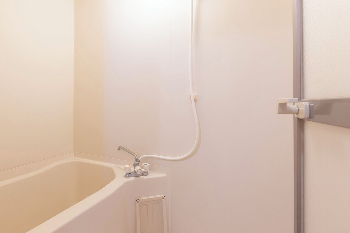 Un baño con bañera, ducha y un perchero para toallas.