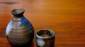 A small ceramic vase and a cup on a wooden surface. - Shiozawasanso (Takayama)
