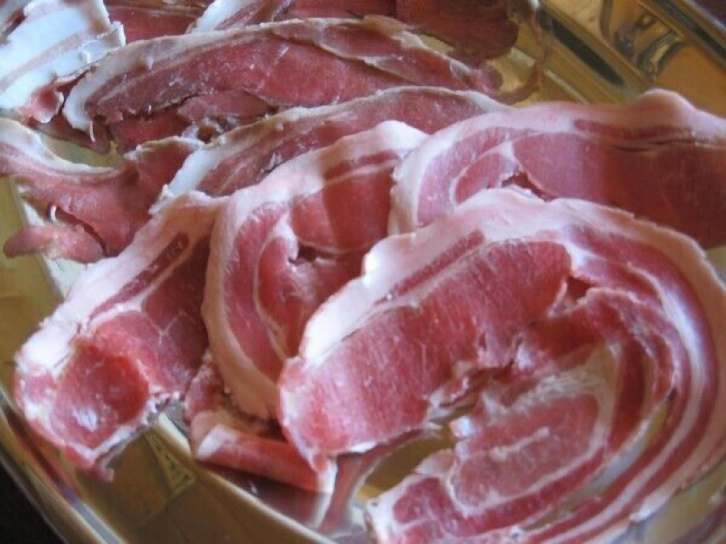 Fette di carne cruda su un vassoio.