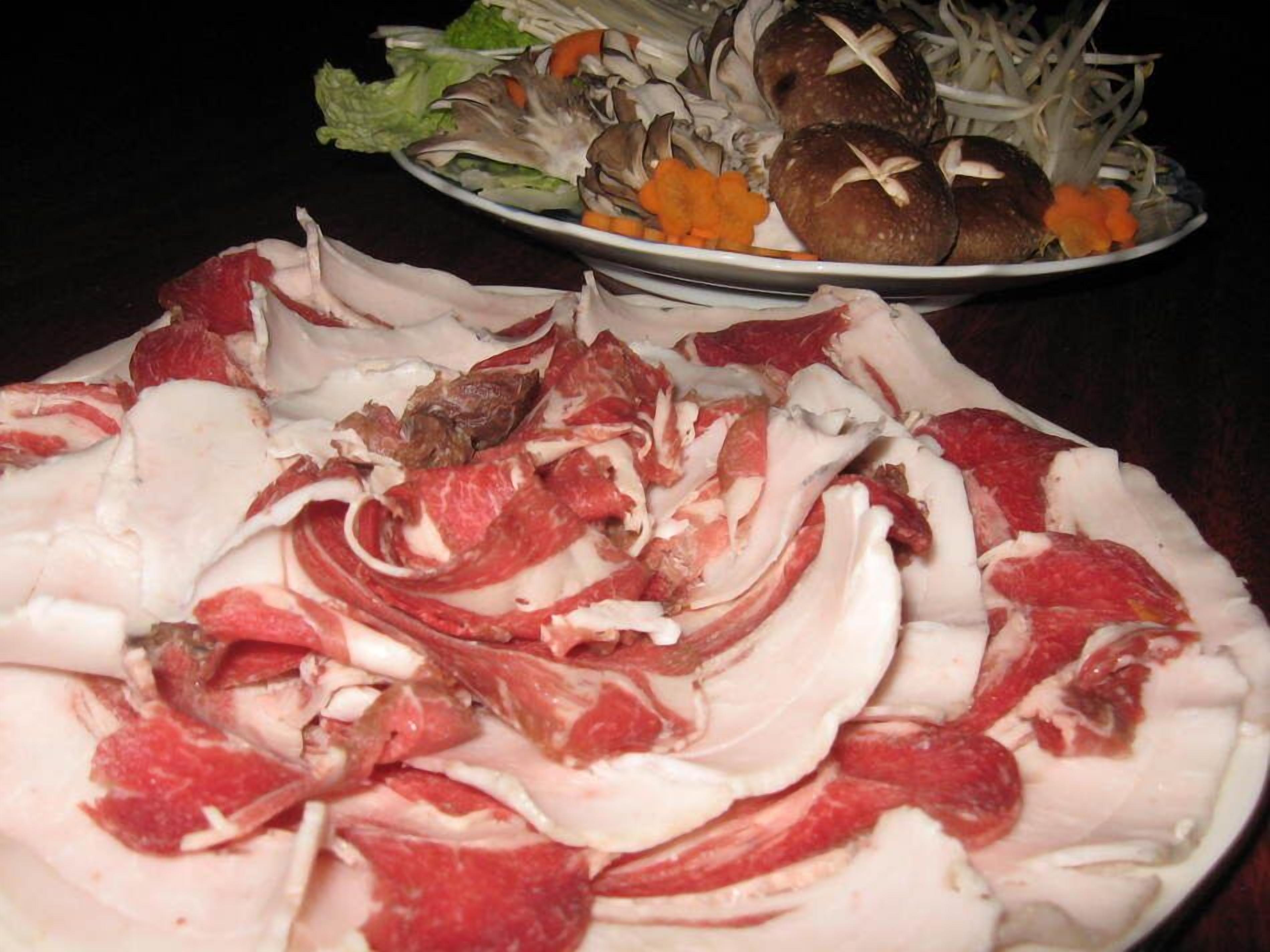 Un plato de carne y verduras cortadas.