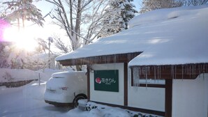 Ein schneebedecktes Gebäude mit einem Schild, auf dem "Hanokrin" steht.