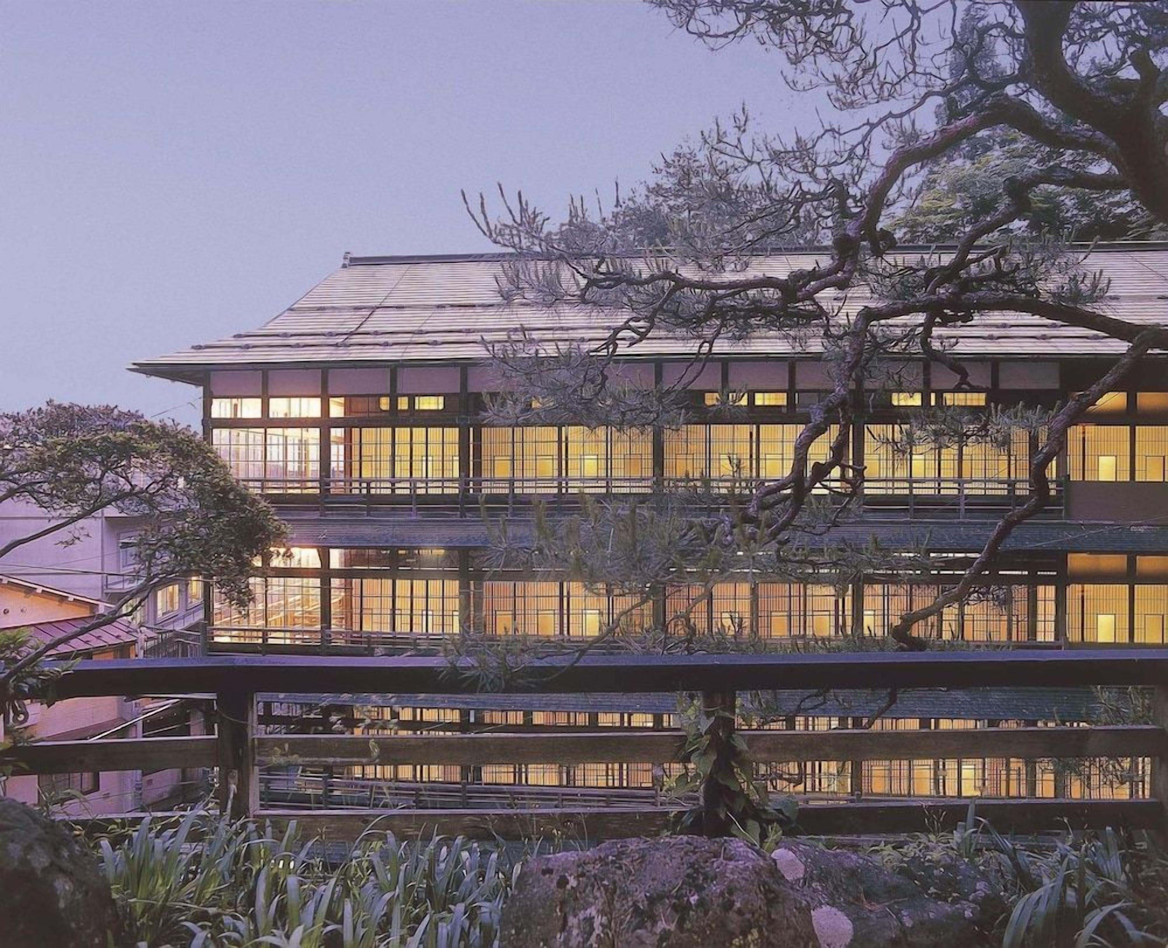 A multi-story building with a modern architectural design, featuring large windows and a flat roof.