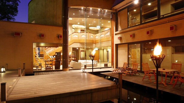 A modern hotel with a spacious outdoor deck, a pool, and a dining area with outdoor seating. - Kounkan (Shibukawa)