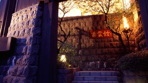 A stone staircase leading to a building entrance with a sign in a foreign language. - Kounkan (Shibukawa)