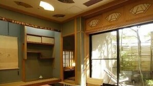 A traditional Japanese room with tatami flooring, a low table, and sliding doors. - Kounkan (Shibukawa)