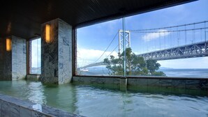 A spa with a large window overlooking a bridge and water. - Bay Resort Hotel Naruto Kaigetsu (Naruto)