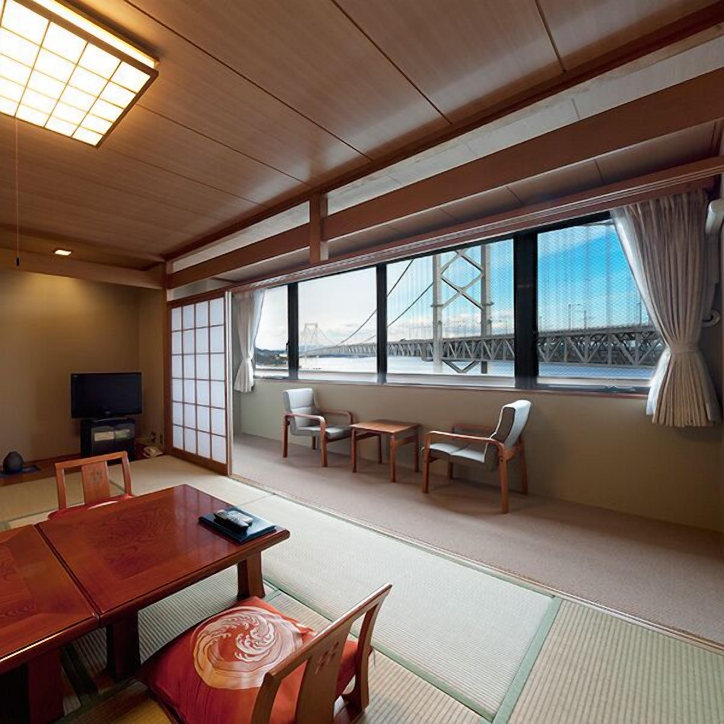 Ein traditioneller japanischer Raum mit Tatami-Bodenbelag, einem niedrigen Holztisch und Stühlen.