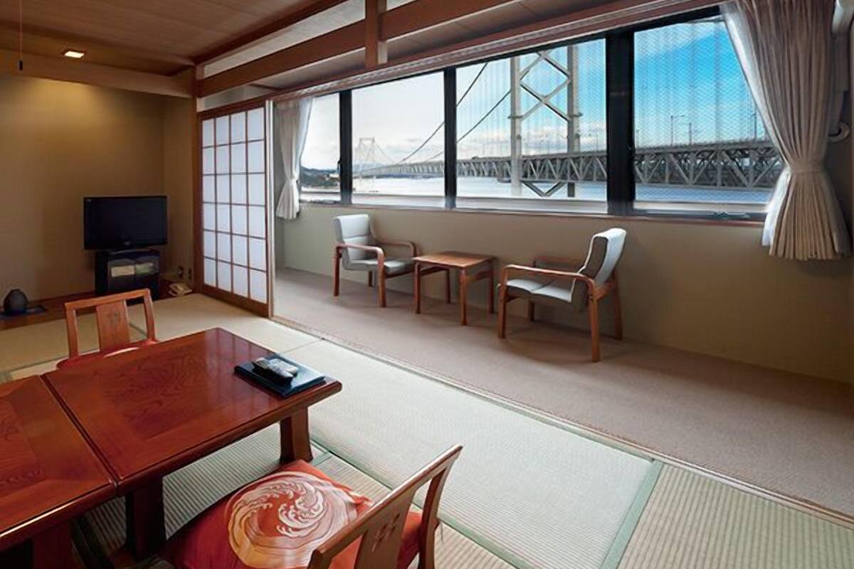 A traditional Japanese room with tatami flooring, a low wooden table, and chairs.