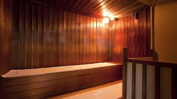 A sauna with wooden walls and a bench.