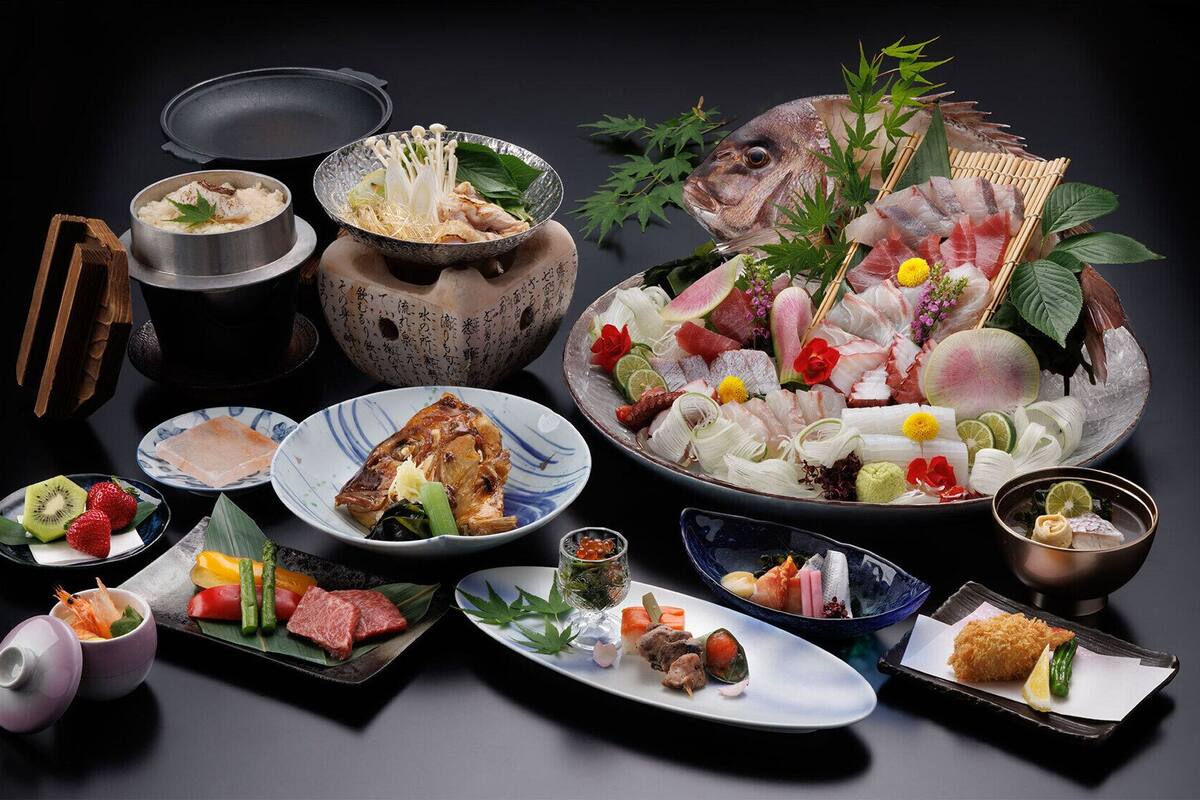 A variety of Japanese dishes arranged on a table, including sushi, sashimi, and other seafood items.